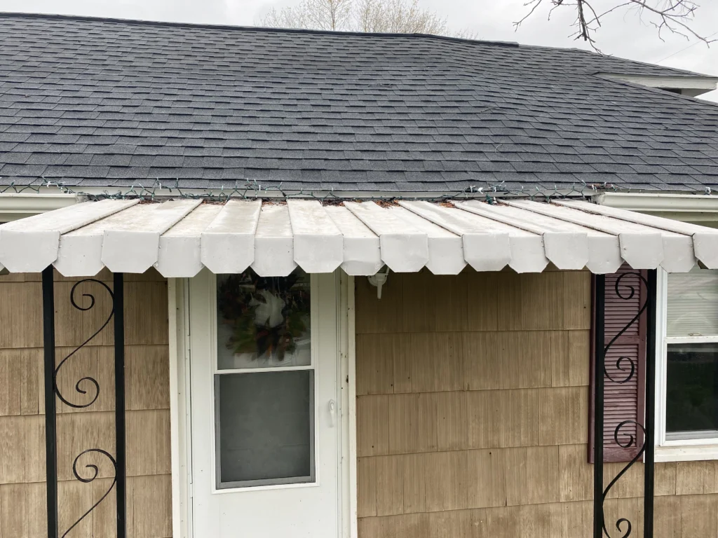 Dirty awning covered in green growth after being cleaned